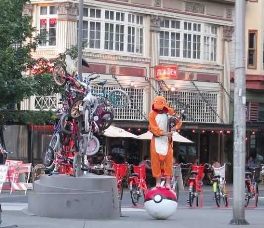 Vestito da Charmander, suona la sigla di Pokémon con una cornamusa su una sferà Poké gigante pokémon